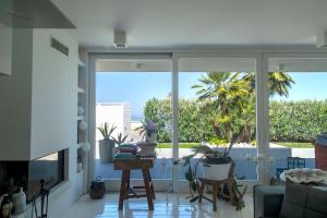 - un salon avec vue sur un palmier dans l'établissement Villa Rosa Del Mare, à Senigallia