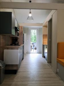 eine Küche mit einem Flur, der zu einer Tür führt in der Unterkunft Hübsches Tiny Cottage Mit Waldblick Im Feriendorf in Mareuil-sur-Lay