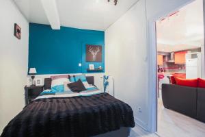 een slaapkamer met een blauwe muur en een bed bij Studio spacieux pour 4 personnes in Clermont-Ferrand