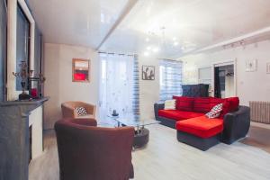een woonkamer met een rode bank en stoelen bij Studio spacieux pour 4 personnes in Clermont-Ferrand