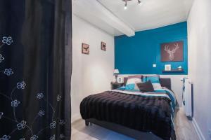 een slaapkamer met een blauwe muur en een bed bij Studio spacieux pour 4 personnes in Clermont-Ferrand