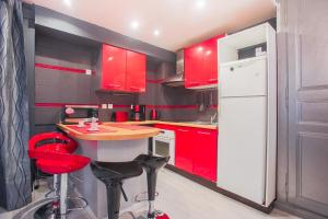 een keuken met rode kasten en een witte koelkast bij Studio spacieux pour 4 personnes in Clermont-Ferrand
