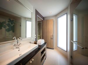 ein Badezimmer mit Waschbecken und großem Spiegel in der Unterkunft Bann Pantai Resort in Cha-am