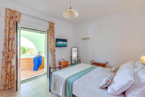 a bedroom with a bed and a balcony at Kallisti Artemis in Kávallos +22 photos
