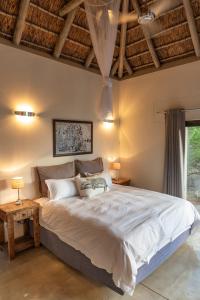Un dormitorio con una cama grande y un techo de madera. en Villa Marula, en Hoedspruit 32 fotos más