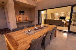 una gran mesa de madera en una sala de estar con sillas en Villa Marula, en Hoedspruit