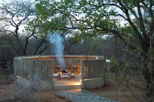 una pequeña casa con un fuego delante de ella en Villa Marula, en Hoedspruit