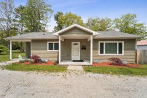 una casa con un vialetto di ghiaia davanti di Spacious 3BR Lakefront Cottage with Stunning Views a Lincoln Junction
