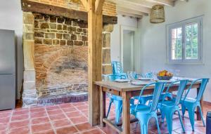 a dining room with a table and blue chairs at Athentique Maison Normande in Vénesville