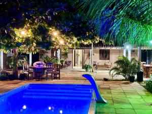a pool in a backyard with a table and chairs at Casa com Piscina Privativa na Lagoa do Paraíso - John House Paradise in Jijoca de Jericoacoara