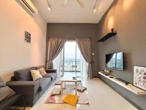 a living room with a couch and a tv at Puchong Skypod 9pax Near Sunway in Puchong