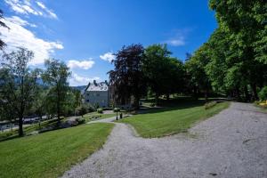 a gravel path through a park with a house in the background at Attractive and central apartment in Ålesund