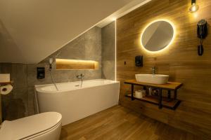 a bathroom with a sink and a tub and a toilet at Villa Park Zwierzyniec in Zwierzyniec +57 photos