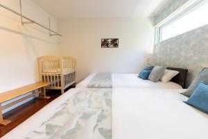 a bedroom with two beds and a crib at Belle Jung Villa Onna in Onna +89 photos