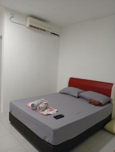 a bed in a white room with avertisementatronatronstrationstrationstration at RoomStay Changloon Berhawa Dingin dan Privasi Penuh in Changlun