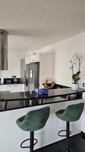 a kitchen with two green chairs sitting on a counter at Villa la Gardiole in Vic-la-Gardiole