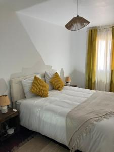 a bedroom with a white bed with two yellow pillows at Villa la Gardiole in Vic-la-Gardiole +45 photos