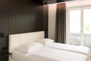 Postel nebo postele na pokoji v ubytování Hotel Velden - 24 Checkin Zimmer im Zentrum