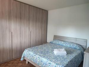 a bedroom with a bed and wooden cabinets at Casetta STELLA MARINA PUNTA SABBIONI in Cavallino-Treporti