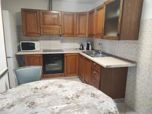 a kitchen with wooden cabinets and a sink and a table at Casetta STELLA MARINA PUNTA SABBIONI in Cavallino-Treporti +17 photos