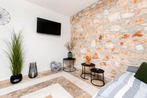 a living room with a stone wall at Apartman Babich in Rovinj
