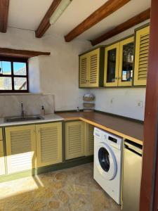 una cucina con armadi gialli e lavatrice di Villa Kostopoulos Studio Zeus a Kampos Paros