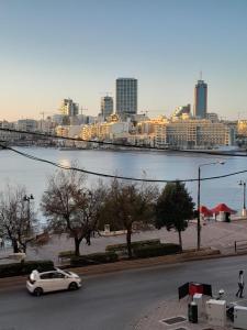 a white car driving down a street next to a river at Cozy Seaview Apartment Sliema S6 in Sliema