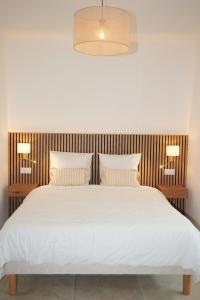 a bedroom with a large white bed with two pillows at La verrière in Avignon