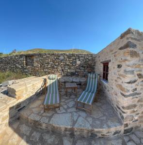 due sedie e un tavolo su un edificio in pietra di Villa Kostopoulos Studio Zeus a Kampos Paros Altre 6 foto