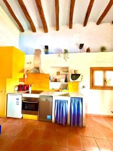 Una cocina con electrodomésticos amarillos y blancos en una habitación. en Cal Capdevila Apartaments, en Pira 31 fotos más