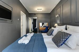 Un dormitorio con una cama grande con toallas. en Młyńska w Centrum Miasta by Downtown Apartments, en Gdansk