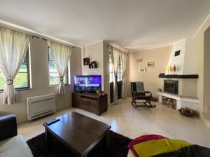 a living room with a tv and a couch and a table at GeshaHillPark villas 55 in Dryanovo