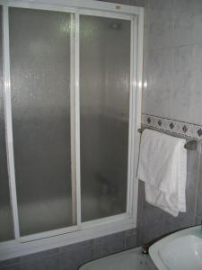 W łazience znajduje się szklane okno i umywalka. w obiekcie Hostal Paracuellos w mieście Paracuellos de Jarama