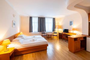 a hotel room with a bed and a desk at Hotel Pannonia in Miskolc