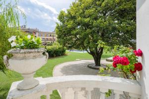 a vase sitting on a white fence with flowers at Villa Rachel Quadro in Intra +26 photos