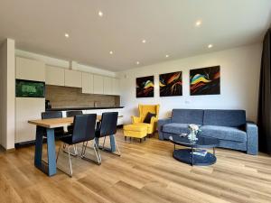 a living room with a blue couch and a table at Vila Katarina - Lake View Apartments in Bled +26 photos