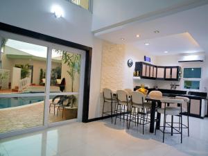 a dining room and kitchen with a table and chairs at Villa James in Tarlac