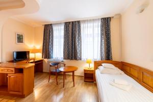 a hotel room with a bed and a desk at Hotel Pannonia in Miskolc
