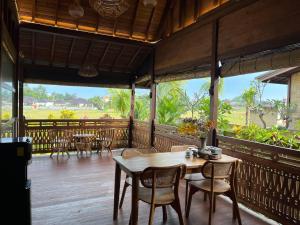 a dining room with a table and chairs on a deck at Villa Gong bali in Ubud