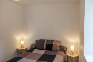 een slaapkamer met een bed met twee lampen aan beide zijden bij les loges de jeanne in Orléans