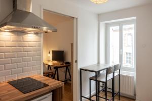 een keuken met een fornuis en een aanrechtblad bij les loges de jeanne in Orléans +3 foto's