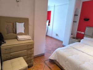 a bedroom with a bed and a dresser with a mirror at Cozy Moroccan House in Agadir