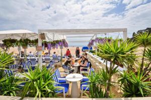 a restaurant on the beach with people sitting in chairs at Apartment Verano Go2lloret in Lloret de Mar