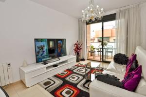 a living room with a couch and a tv at Apartment Verano Go2lloret in Lloret de Mar
