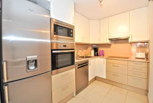 a kitchen with stainless steel appliances and white cabinets at Apartment Verano Go2lloret in Lloret de Mar +17 photos