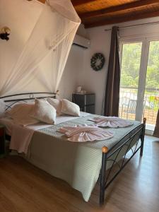 a bedroom with a bed with a canopy at Eros Beach Hotel in Benitses