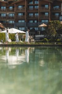 grupa ludzi przechodzących przez zbiornik wody w obiekcie Ferienwelt Kesselgrub Hotel in Altenmarkt-Zauchensee w mieście Altenmarkt im Pongau
