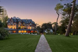 a large house with a lawn in front of it at Le Castel Marie Louise in La Baule