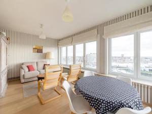 a living room with a table and chairs and a couch at Luxury 2-bedroom apartment with marina views in Blankenberge T205 in Blankenberge