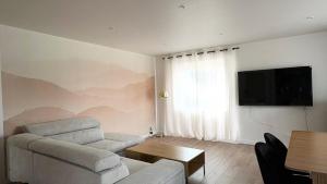 Μια τηλεόραση ή/και κέντρο ψυχαγωγίας στο Appartement 3 chambres avec jardin et garage